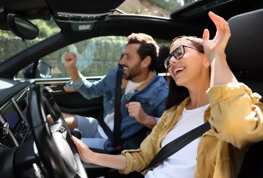 Kvinne og mann sitter i bil og digger musikken